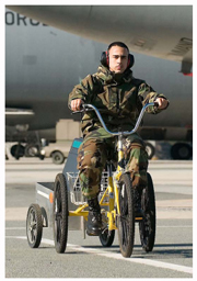 Figure 2: An Airman transports parts via bicycle at Dover AFB